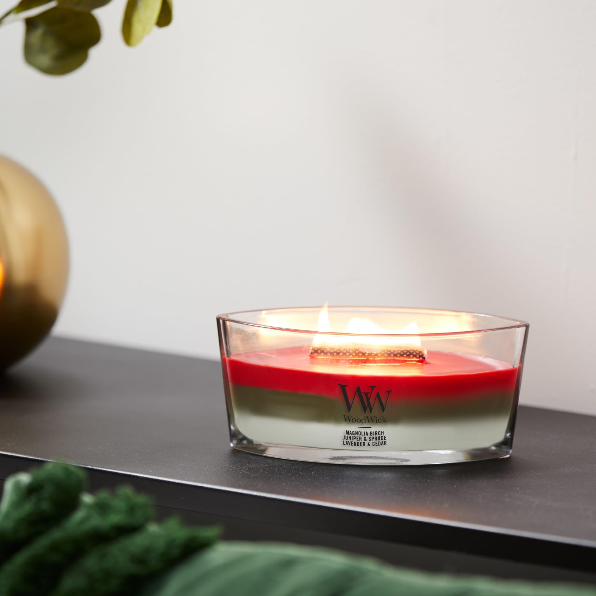 WoodWick candle held in hand for scale showing 16 oz ellipse size and gift readiness