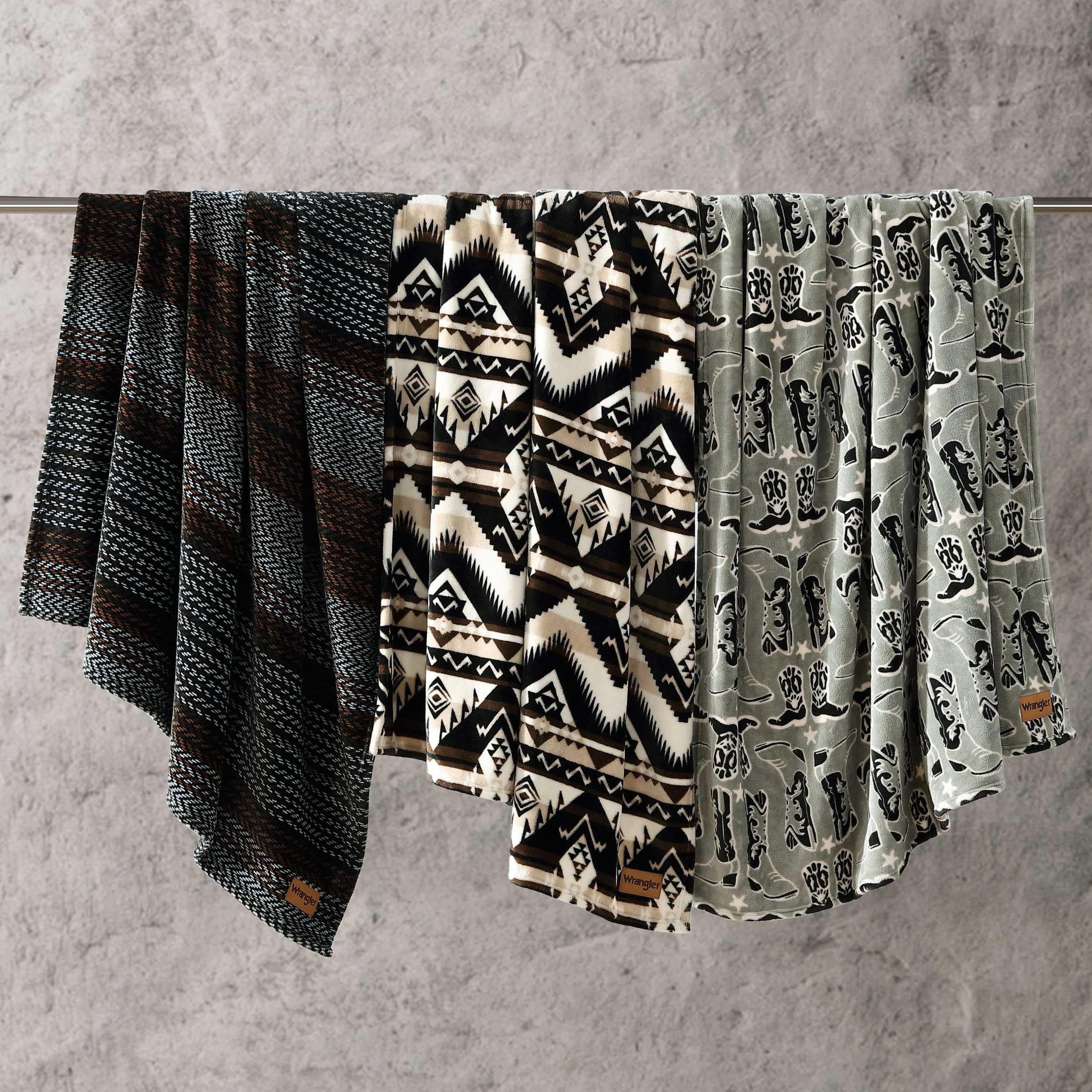 Wrangler folded throw next to book showing compact travel-friendly size