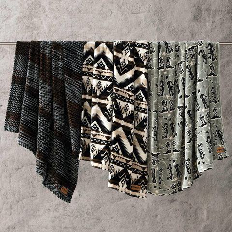 Wrangler folded throw next to book showing compact travel-friendly size