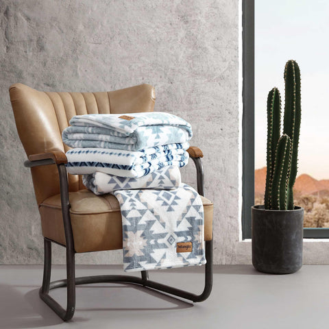 Wrangler throw beside a book showing size and easy portability