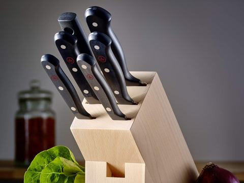 Wüsthof paring knife next to coin for scale showing compact size and easy storage