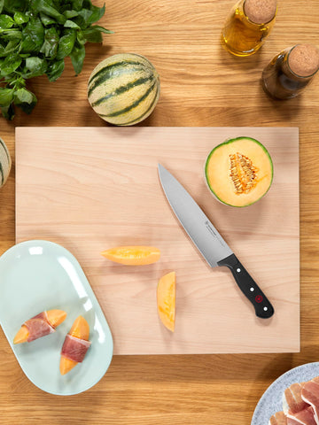 Wüsthof knife shown next to hand to demonstrate lightweight, balanced scale