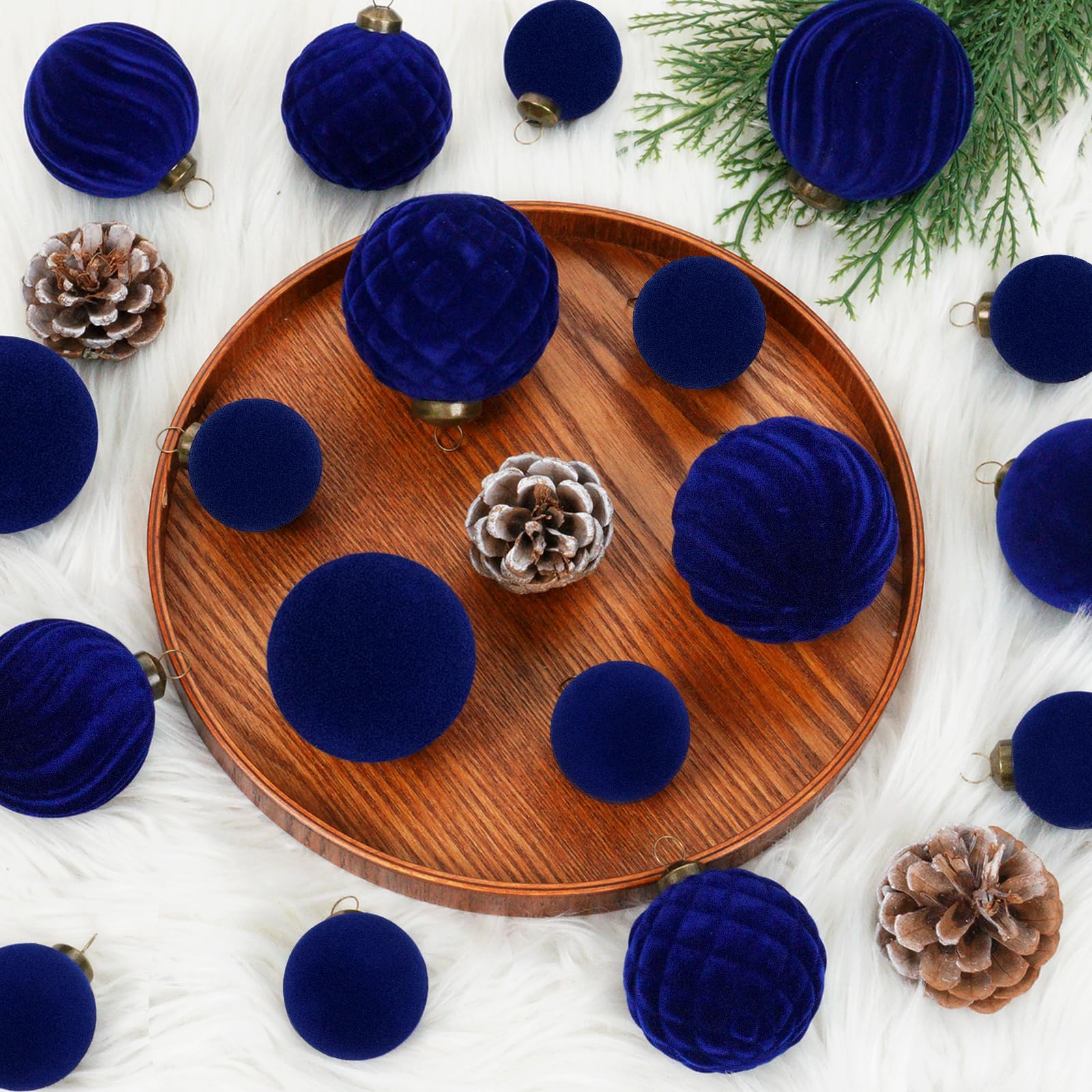 XmasExp ornaments hanging on a lit tree adding rich navy tone and cohesive styling