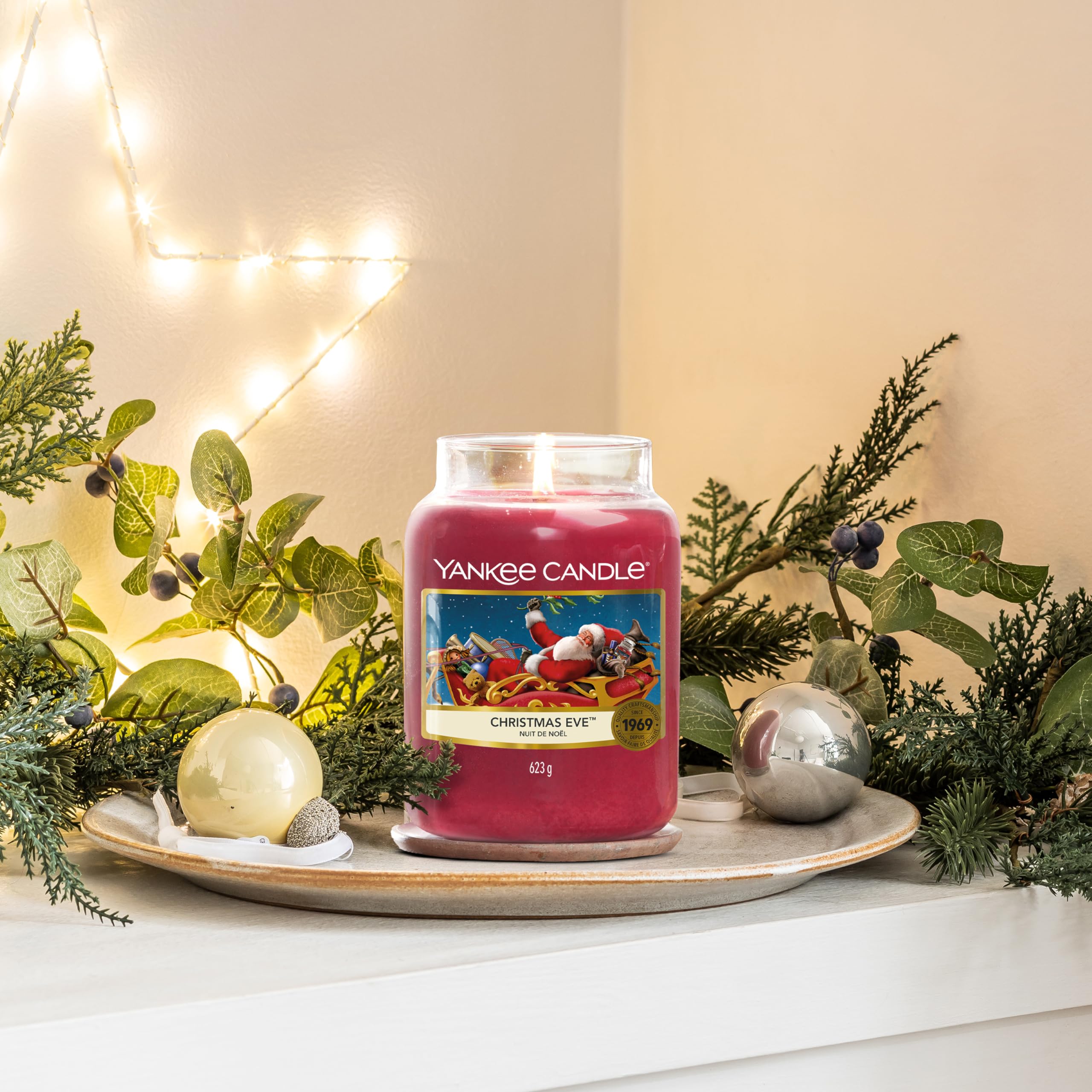 Yankee Candle next to a ruler showing 6.6 inch height and 22oz scale benefit