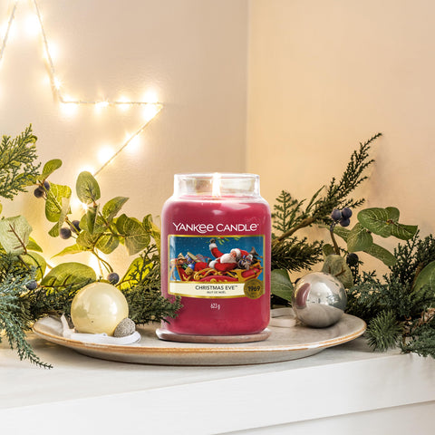 Yankee Candle next to a ruler showing 6.6 inch height and 22oz scale benefit