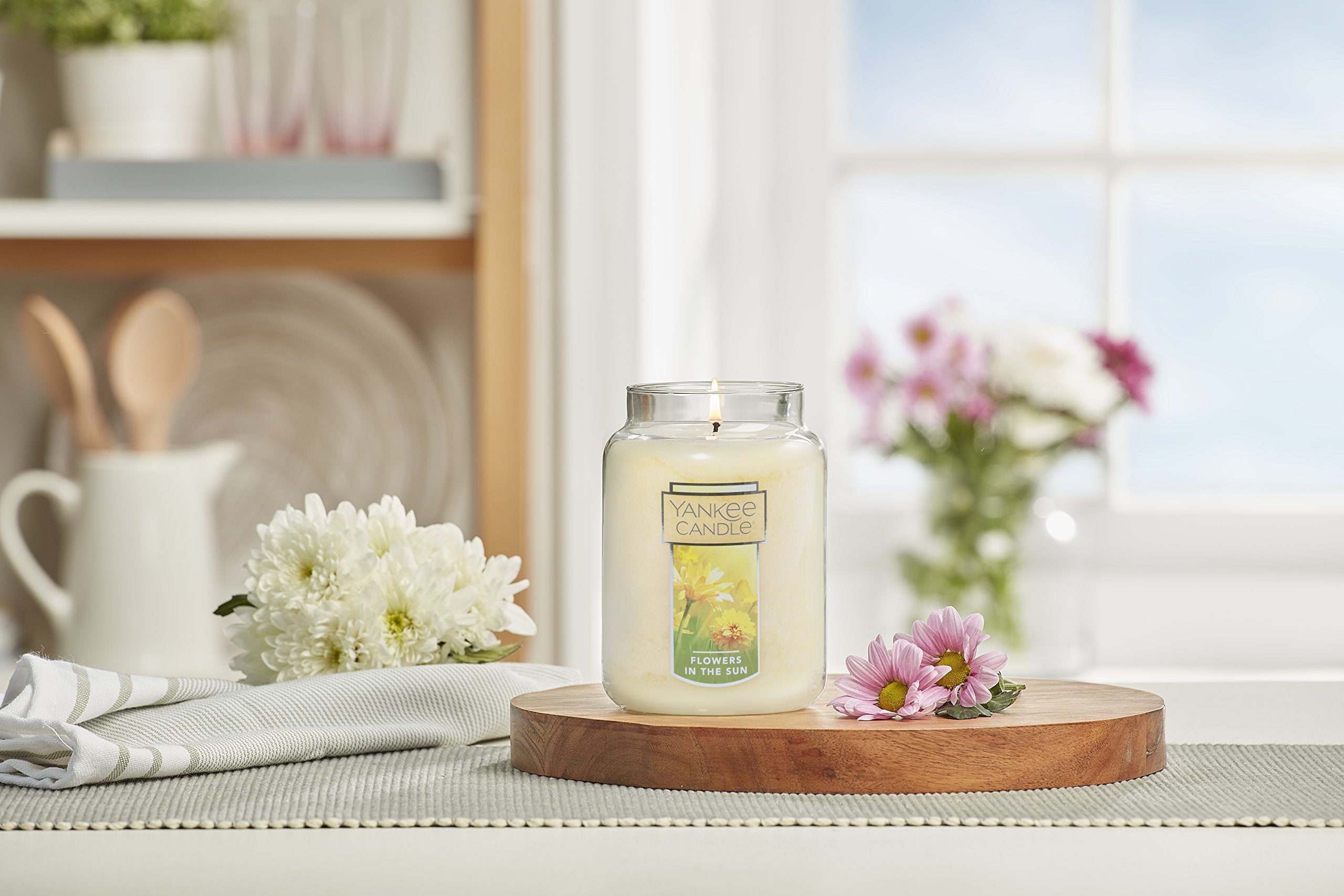 Yankee Candle next to household items for scale, long burn time benefit