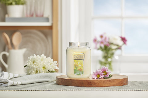 Yankee Candle next to household items for scale, long burn time benefit