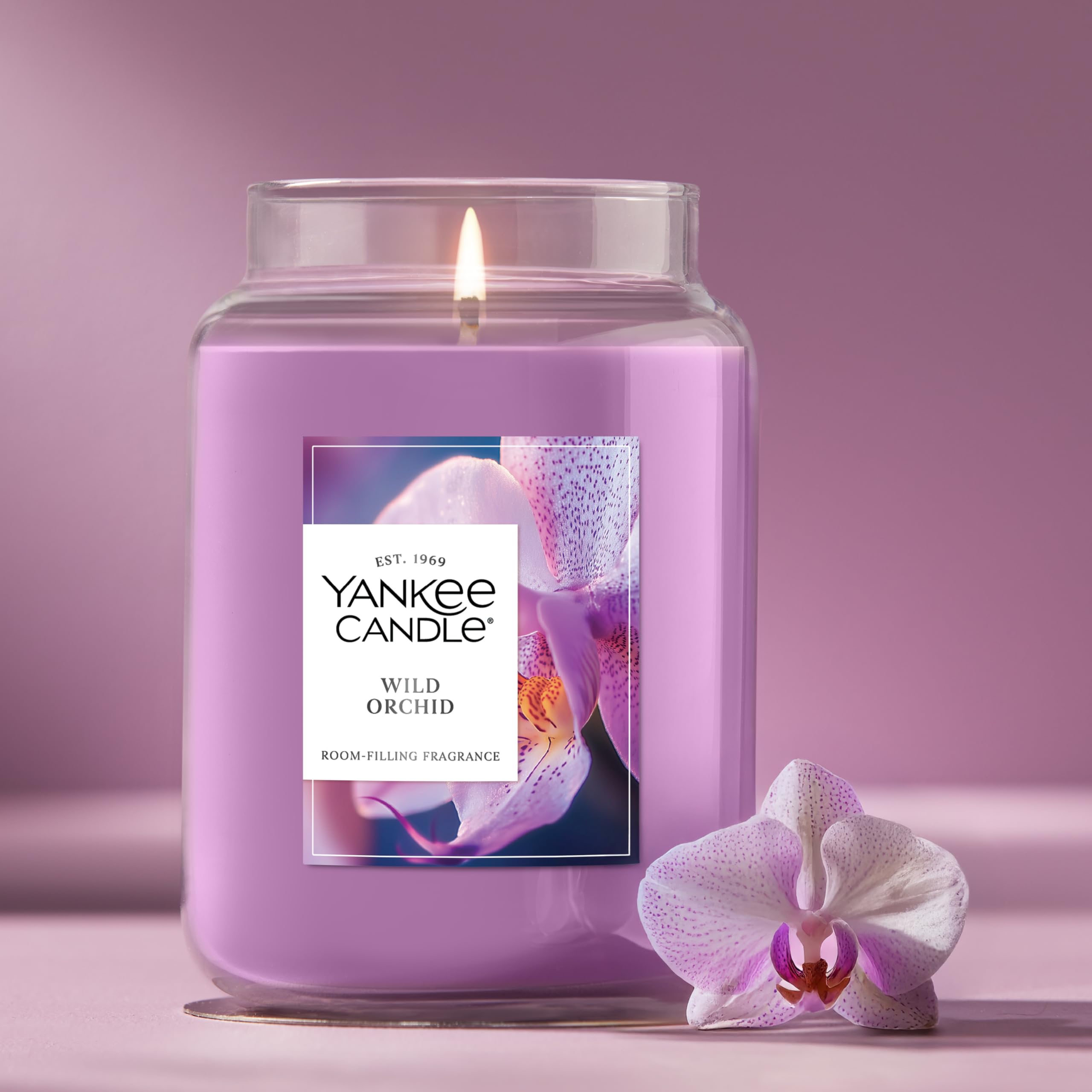 Yankee Candle Wild Orchid beside a book to show 22oz size and scale