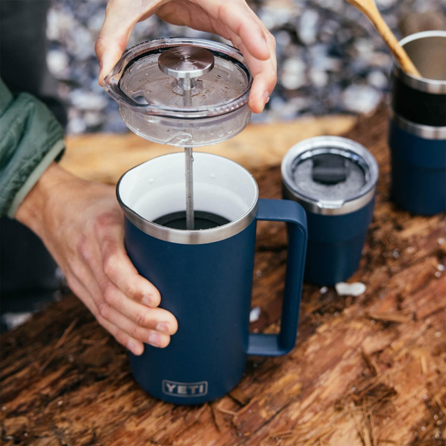 YETI 34 oz French Press beside a hand and mug for size and capacity clarity