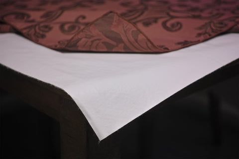 Yourtablecloth on a dining table under linen showing protection from heat and everyday spills