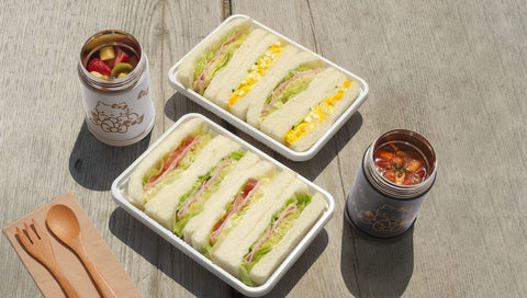 Zojirushi Hello Kitty beside a water bottle showing 17 oz size for meal planning